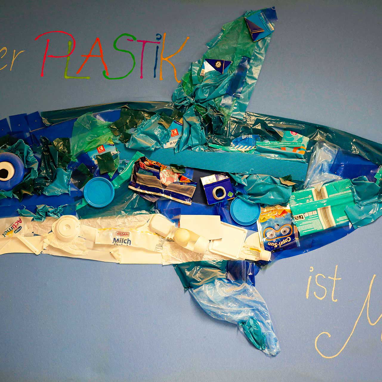 Ein selbstgebastelter Wal aus Plastikabfällen mit der Aufschrift: Weniger Plastik ist Meer.