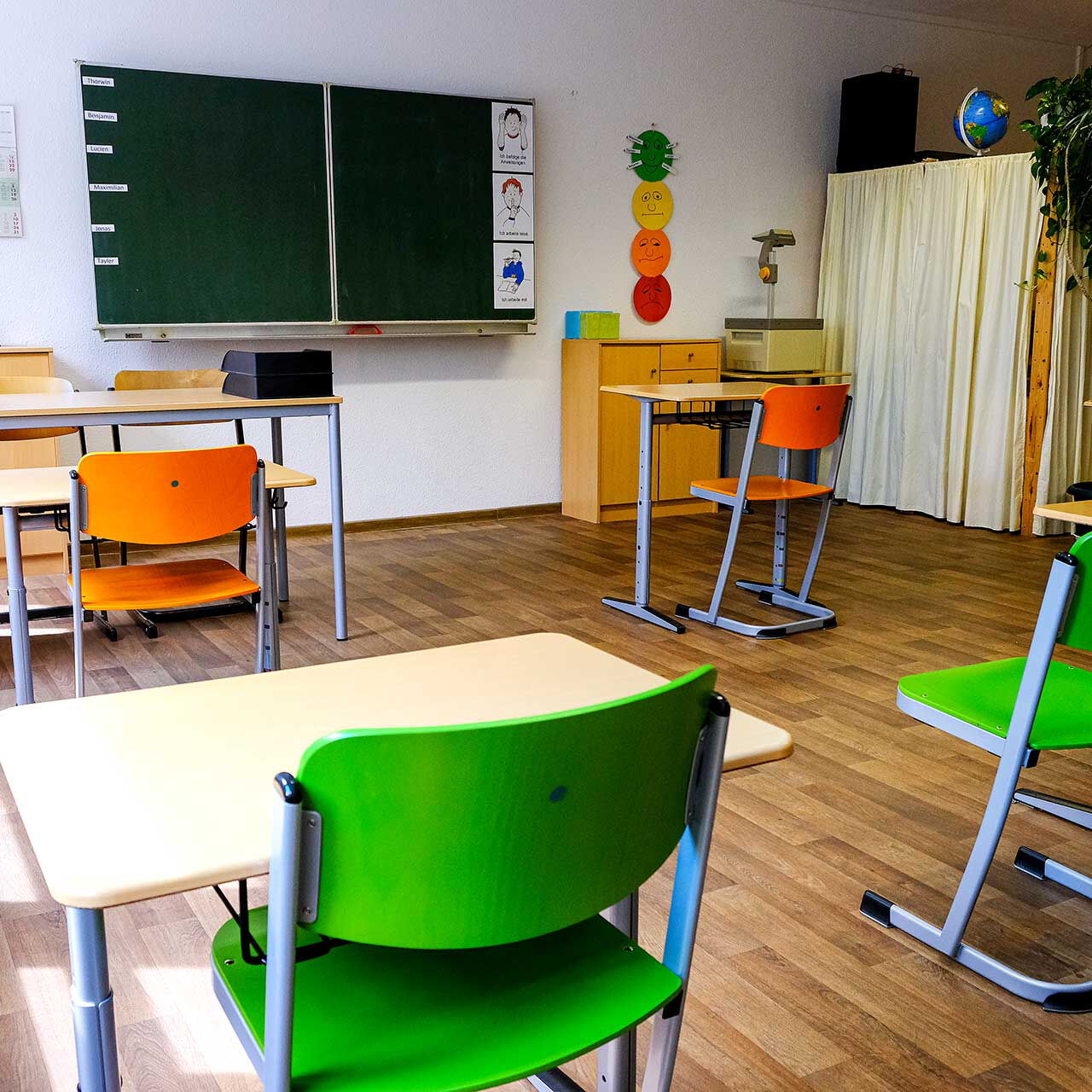 Ein Klassenzimmer mit 5 Einzelplätzen, einem Lehrertisch und einer Wandtafel.