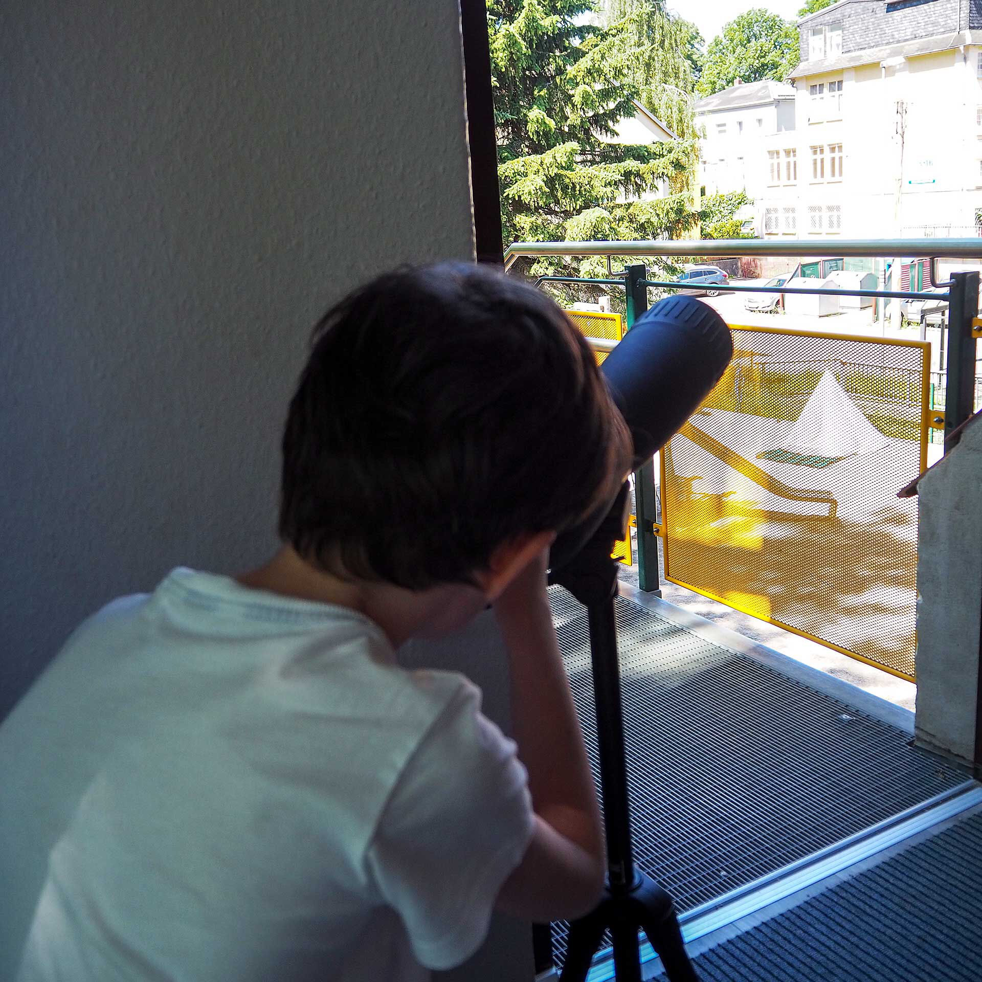 Ein Kind schaut durch ein Fernrohr.