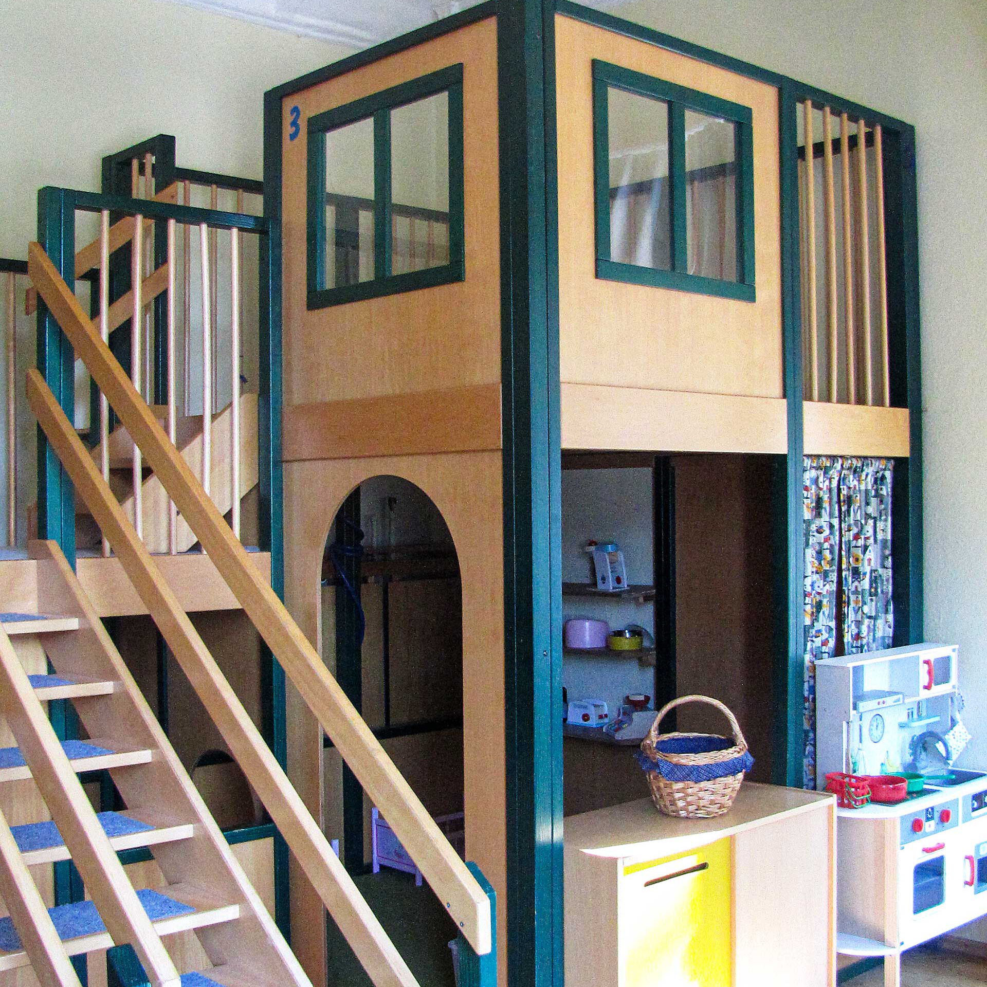Ein Spielturm aus Holz mit einem Unterstand, Spielküche und einem Hochstand zum hochsteigen.