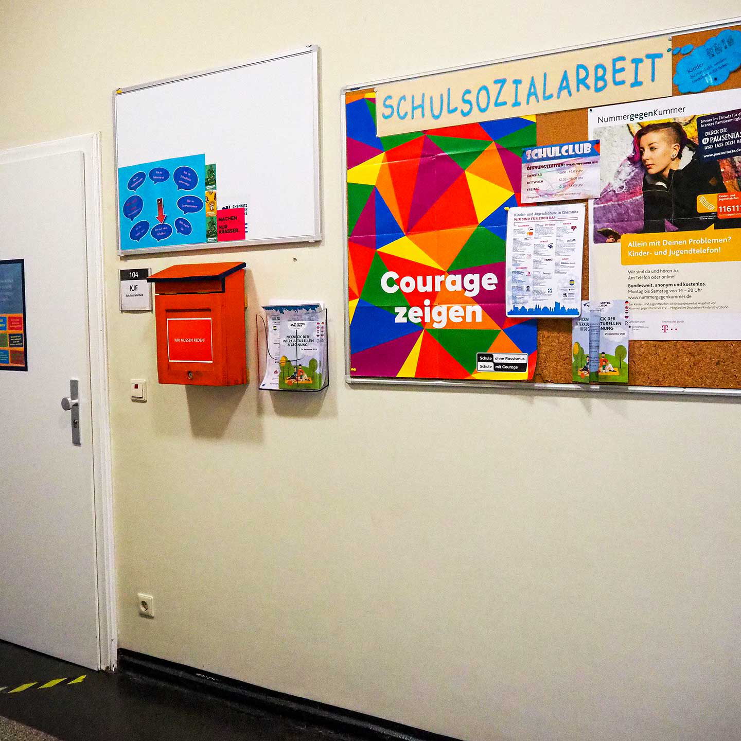 Im Eingangsbereich der Integrationsbegleitung hängt eine Pinnwand, ein Briefkasten und Whiteboard.