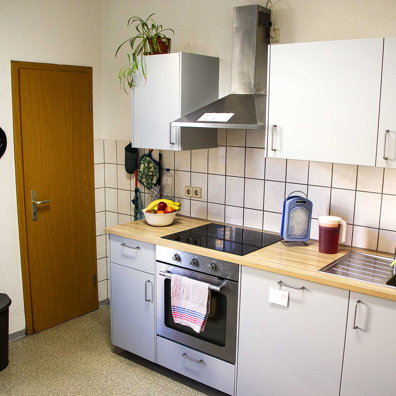 Eine Küche mit einer kleinen Küchenzeile und Elektrogeräten.